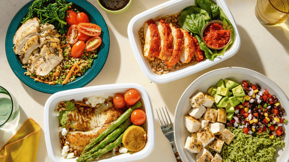 four meals from CookUnity made by their award-winning chefs. one meal has grilled chicken with farro, the other has tofu, one is tilapia with fresh tomatoes and asparagus