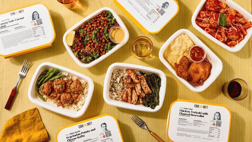 Six CookUnity chef-prepared meals in white containers including kale caesar salad, chicken teriyaki, vegetarian kofta, grilled chicken, pasta, and fried chicken displayed on a yellow background