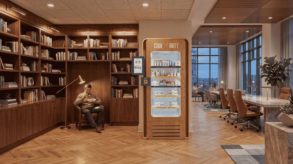 CookUnity smart fridge installed in a luxury apartment building library lounge with a resident eating a meal nearby and no property staff required